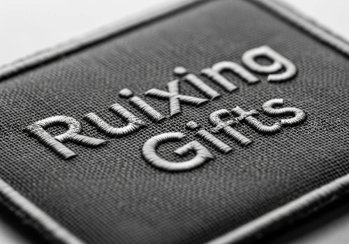 A close-up of a custom embroidered patch, showing the raised, textured stitching of the logo.