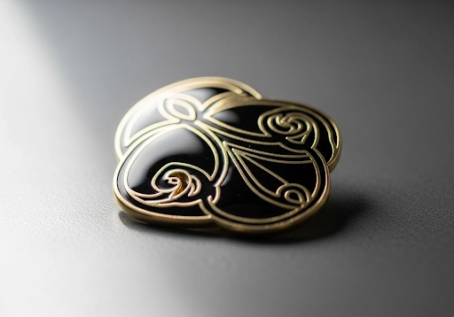 A close-up of a hard enamel pin, showing its smooth, polished, and flat surface.