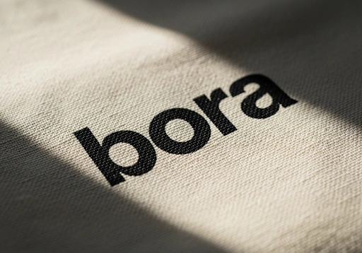 A close-up of a bold, single-color logo screen-printed onto a cotton bag.