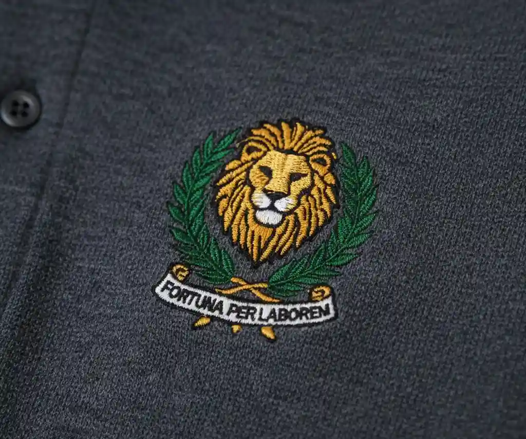 A detailed macro shot of a crisp, multi-color embroidered logo on the chest of a pique knit polo shirt.