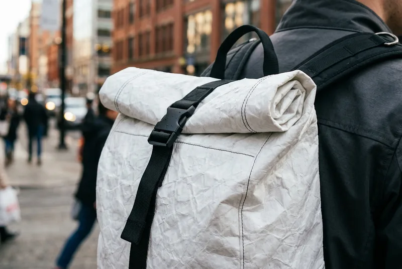 DuPont Tyvek rolltop backpack showing paper-like crinkled texture on an urban commuter.
