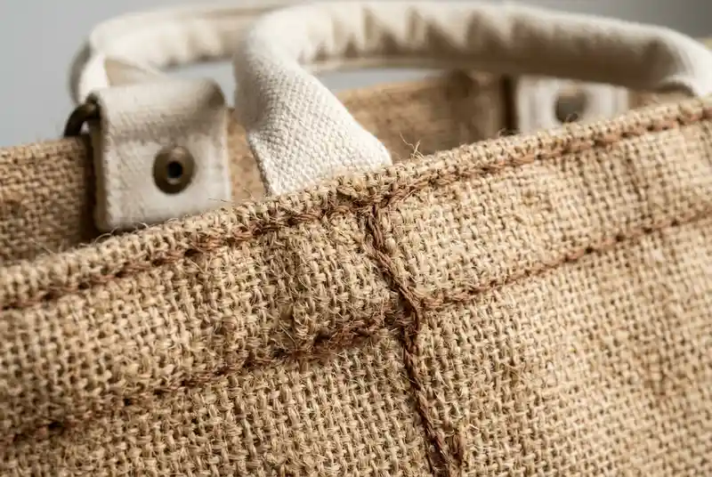 Rustic brown custom jute tote bag with thick woven natural texture and cotton handles.